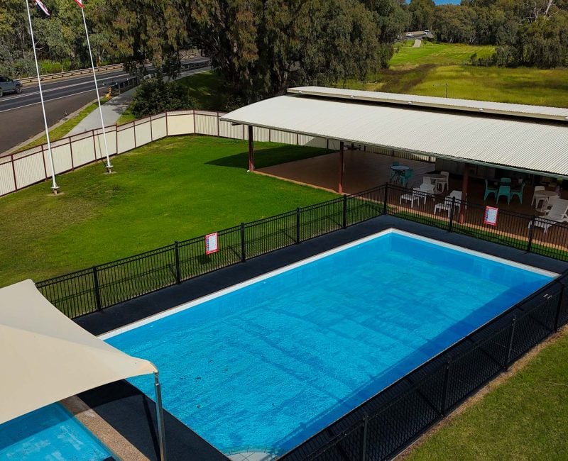 An elevated, wide-angle view of a motel's outdoor swimming pool and recreational area.
