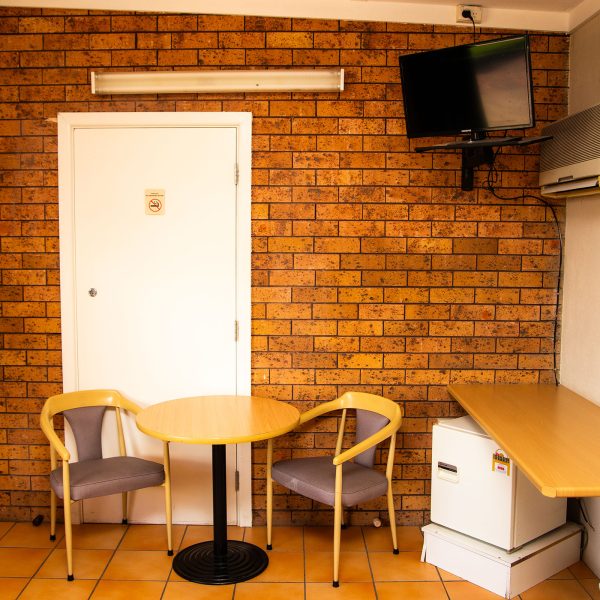 Nandewar Motor Inn room wall mostly covered in red-brown brick veneer.