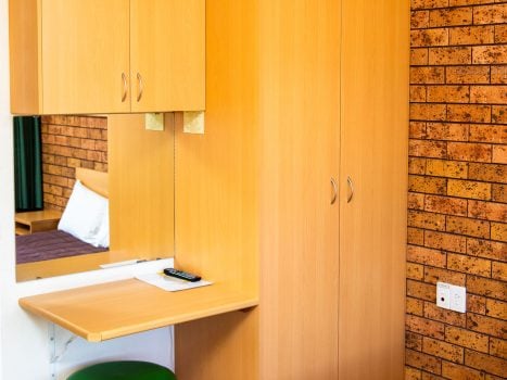 A tall, light-toned, wooden cabinet unit is built into the corner of the room.
