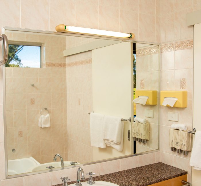 A bright, modern motel bathroom vanity area.
