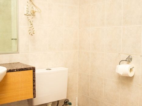 Nandewar Motor Inn's bathroom area with walls tiled in large, square, light beige or pale pink marbled tiles.
