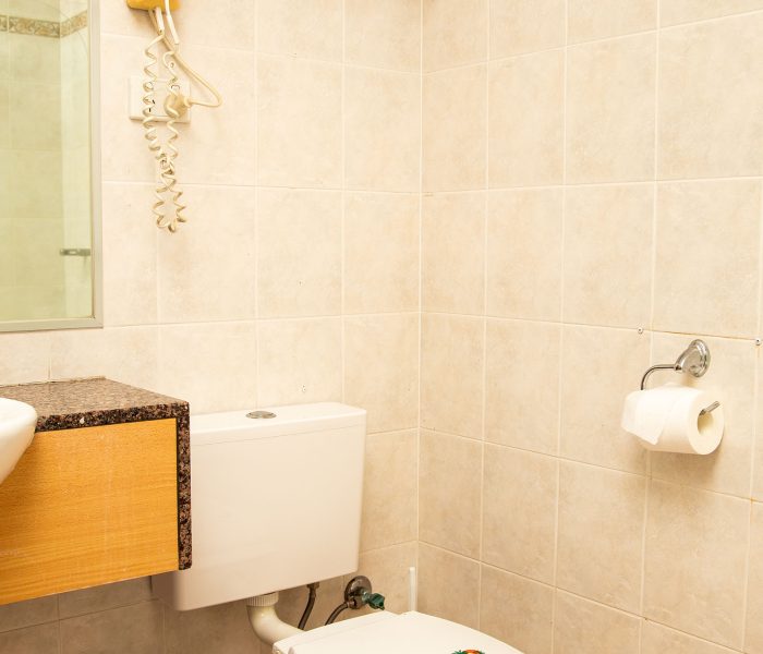 Nandewar Motor Inn's bathroom area with walls tiled in large, square, light beige or pale pink marbled tiles.