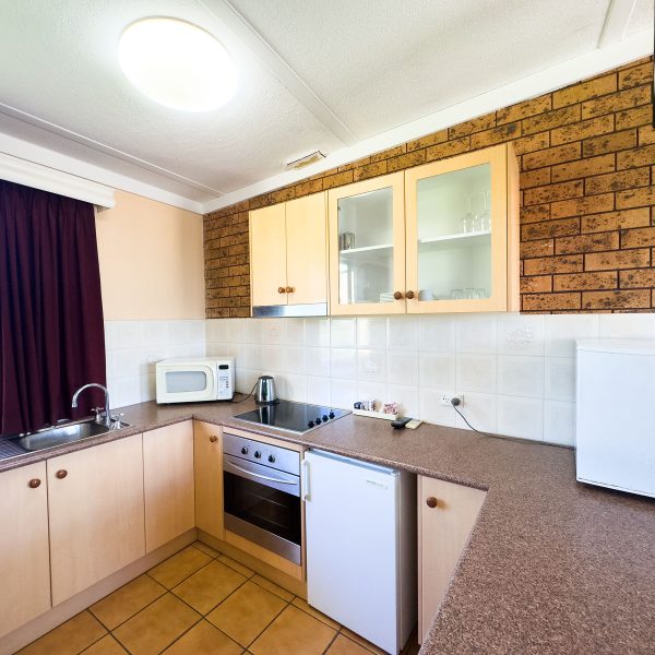 A close-up of a fully equipped kitchenette area in Nandewar Motor Inn room.