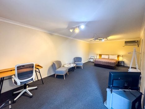The full interior of Nandewar Motor Inn's room with distinct sleeping, lounge, and work areas.