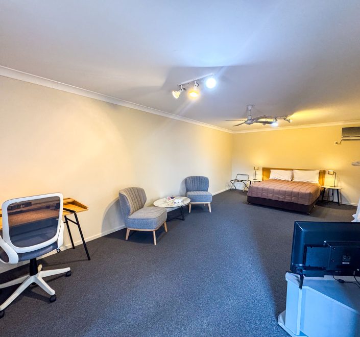 The full interior of Nandewar Motor Inn's room with distinct sleeping, lounge, and work areas.