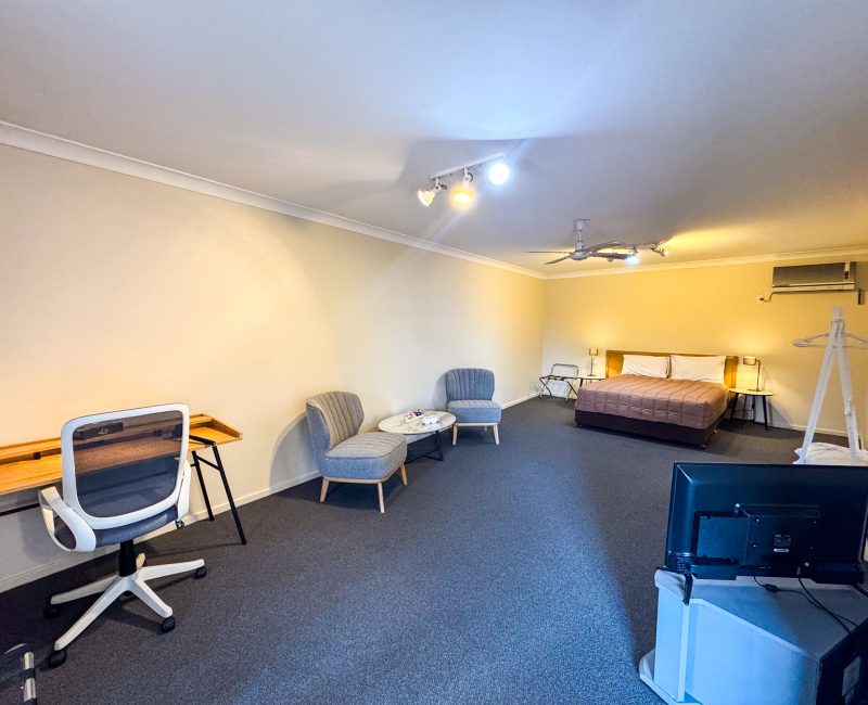 The full interior of Nandewar Motor Inn's room with distinct sleeping, lounge, and work areas.